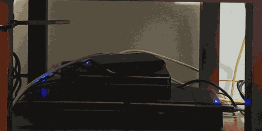 an open laptop sitting on a small table. there are many cables plugged into it.